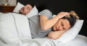 Women struggling to sleep because of her husbands snoring